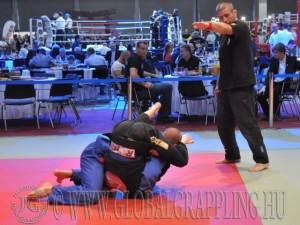 Fekete Sándor leszorítást mutat, Semmy Schilt is a mérkőzést figyeli