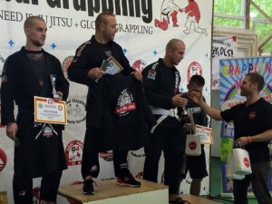 Ámán Krisztián átadja az ajándékcsomagokat a Gi Férfi Open 80+ kg kategória dobogósainak